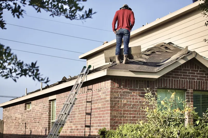 Professional roofer working on a residential roof in Downs